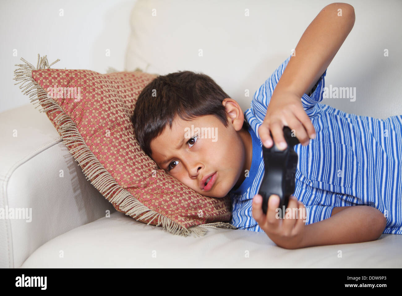 Young boy playing computer game while relxing on the sofa Stock Photo