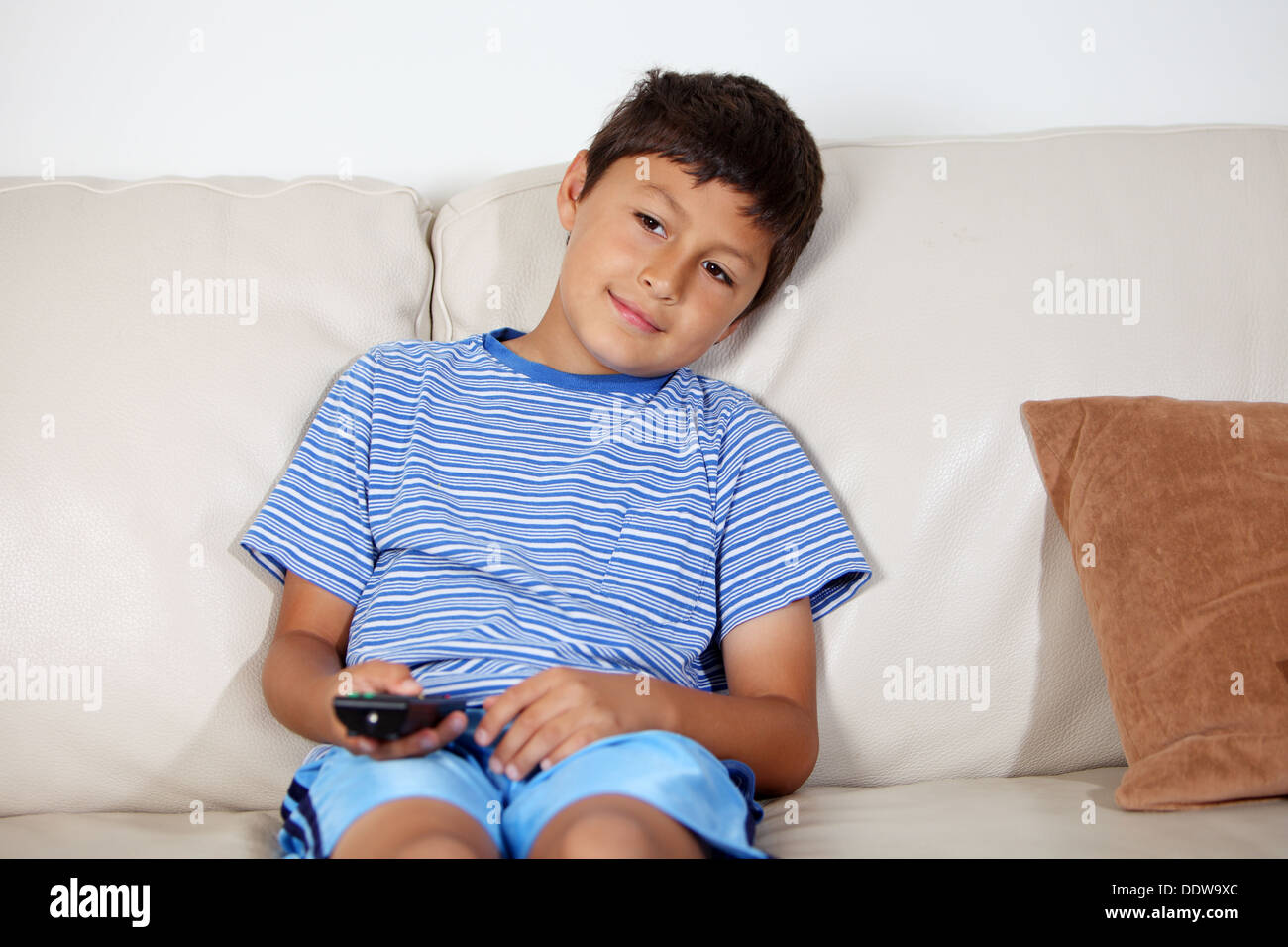 Young boy watching TV with remote control Stock Photo