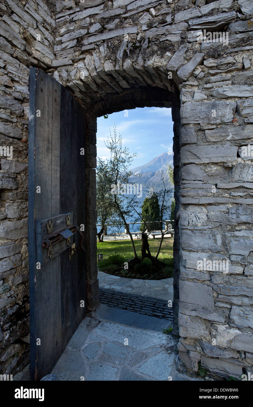 Doorway , Castello di Vezio, Lake Como, Northern Italy, with wooden door and ancient rusty bolt, showing view of gardens and mou Stock Photo