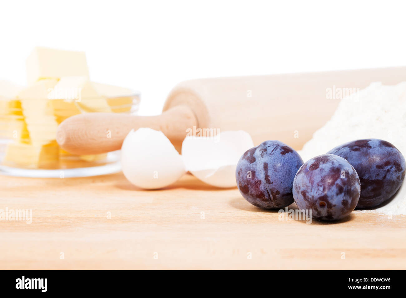 closeup of plums for baking in front of baking ingredients and tools Stock Photo