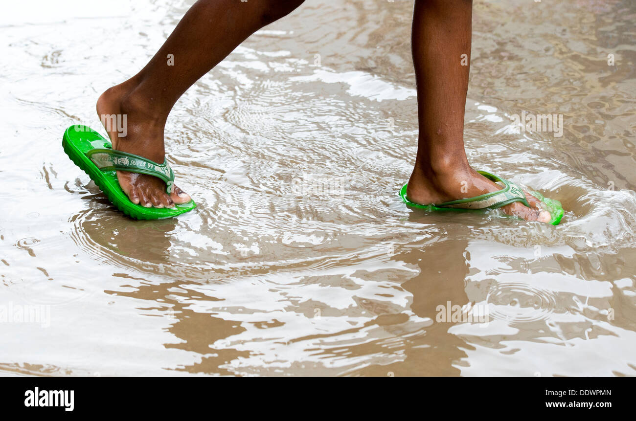 Indian boys feet wearing flip flops walking through rain puddles. India  Stock Photo - Alamy