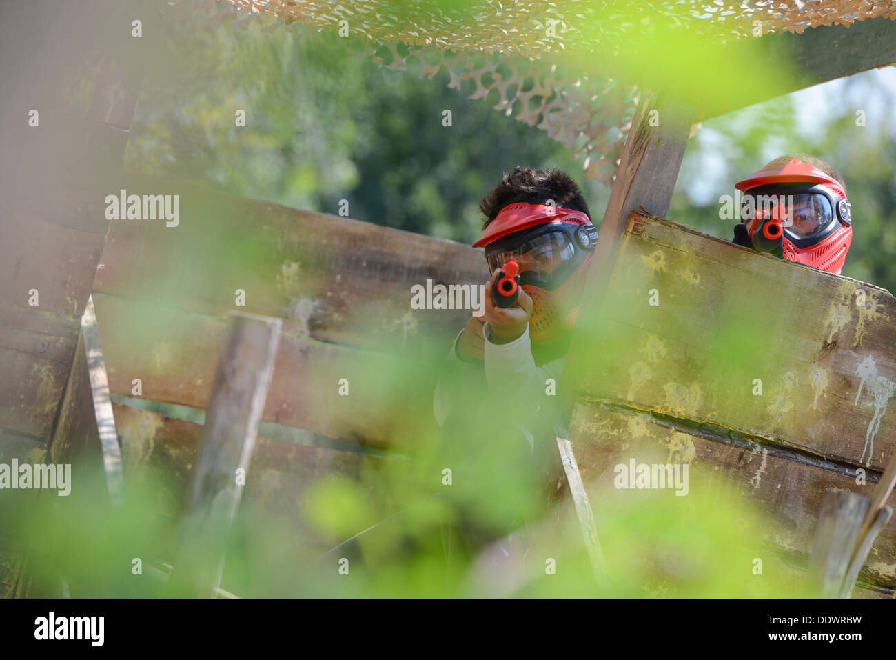 Young children playing paintball in the woods Stock Photo Alamy