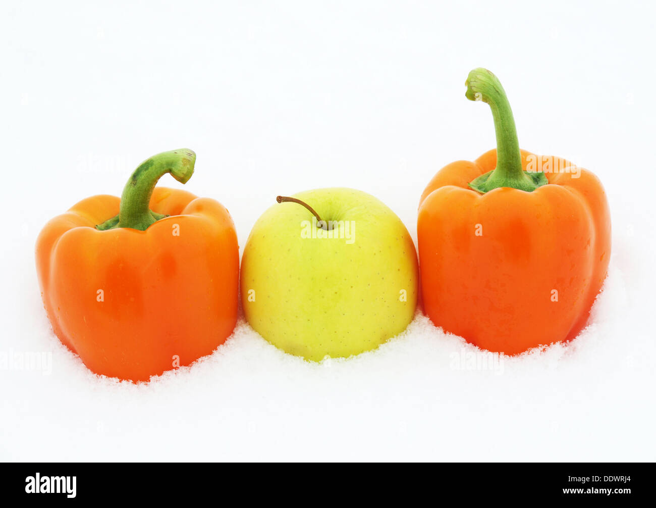 Peppers and apple on snow Stock Photo