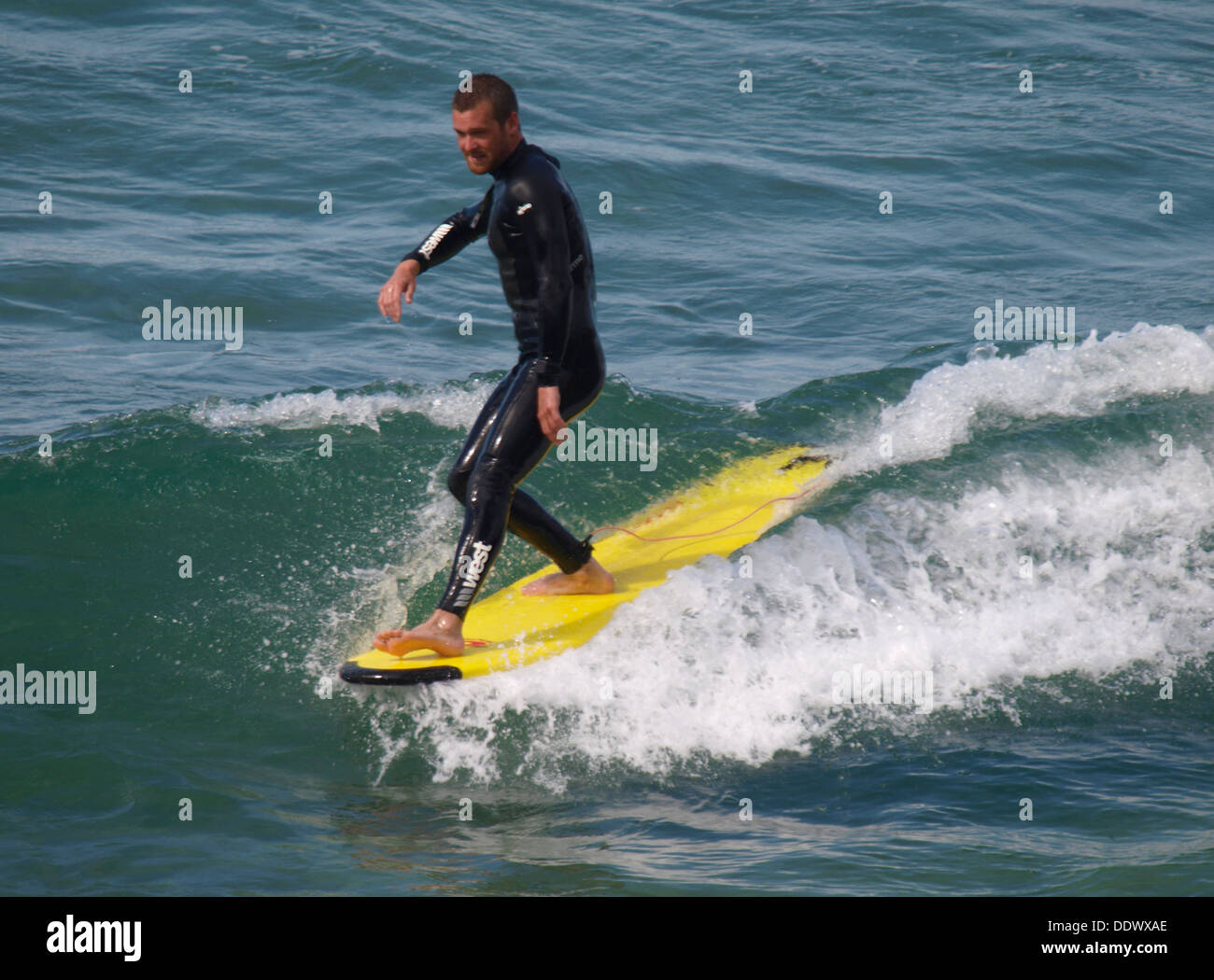 Surfer on a longboard, Trebarwith Strand, Cornwall, UK 2013 Stock Photo