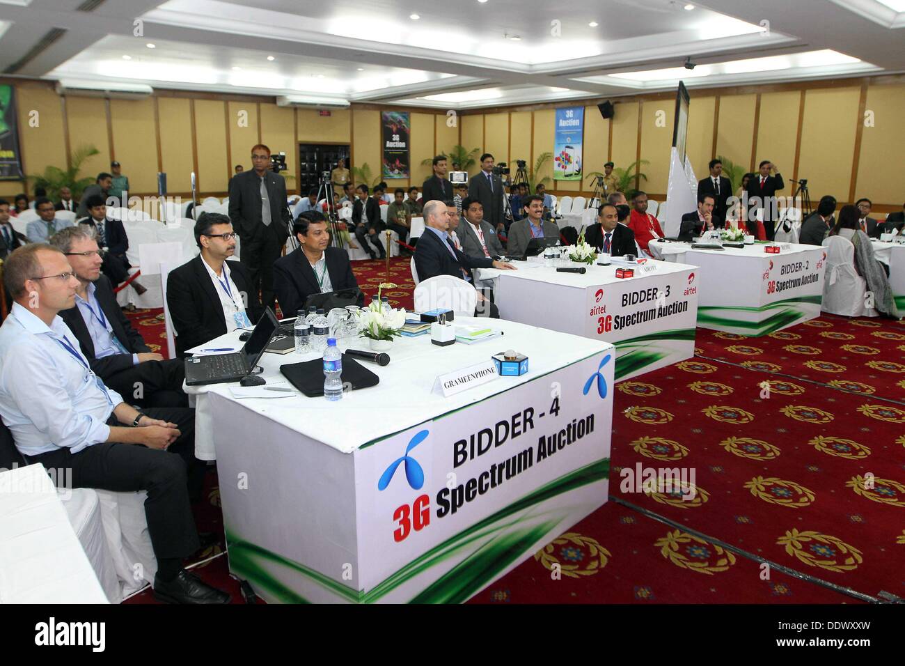 Dhaka, 8th Sep, 2013. Four telecoms operators bidding teams of Grameenphone, Banglalink, Robi and Airtel are seen during 3G spectrum auction held at Ruposhi Bangla Hotel in the capital Dhaka . Four telecom operators of the country acquired 25 megahertz (MHz) of spectrum Sunday when the long-awaited auction for 3G (third generation) was held in the capital. In the first phase of the auction, market leader Grameenphone acquired 10 megahertz (MHz) of spectrum at the price of $210 million. In the second phase, Banglalink, Robi and Airtel each acquired 5 MHz of spectrum. Stock Photo