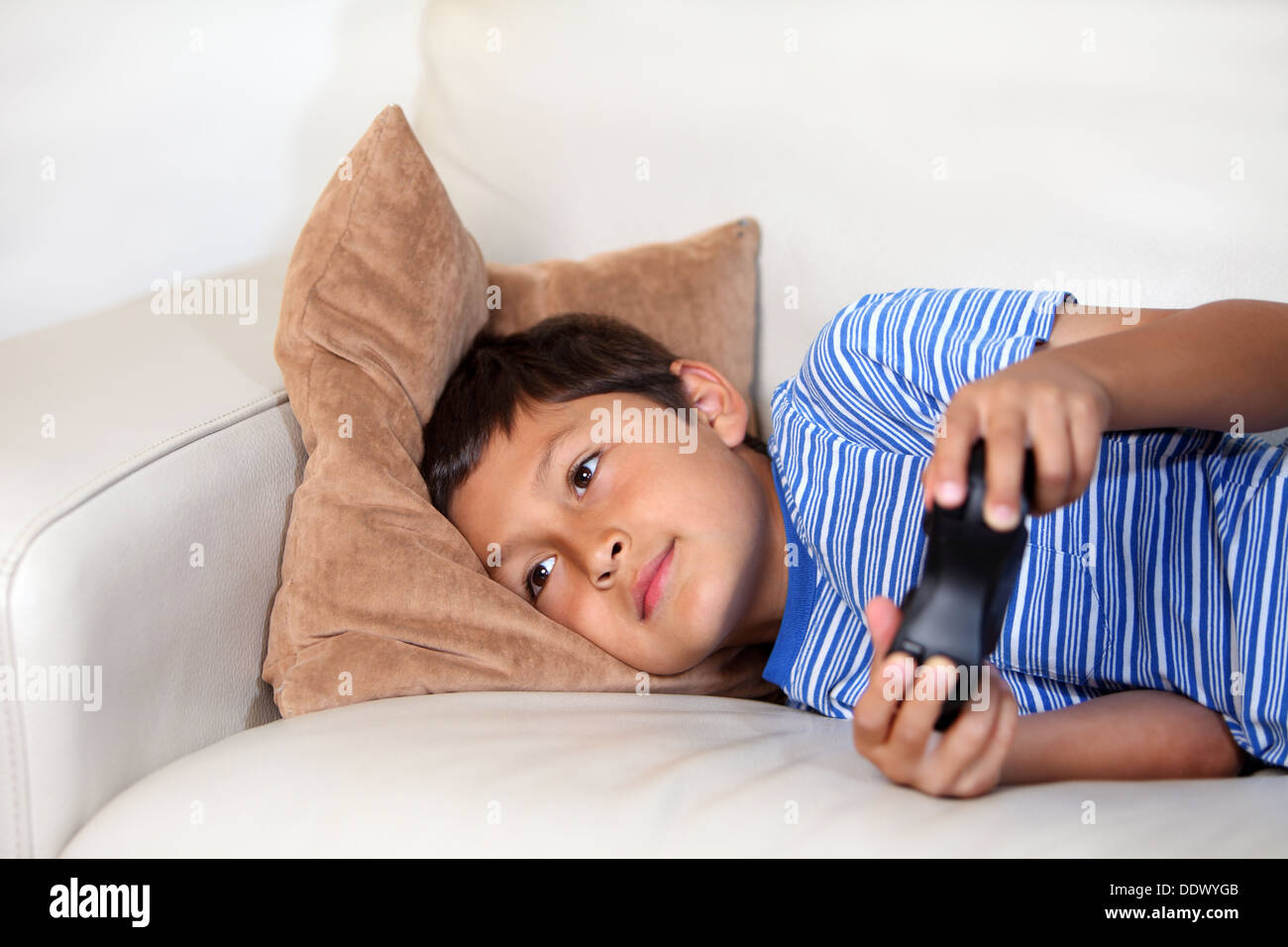 Young boy playing computer game while relxing on the sofa Stock Photo