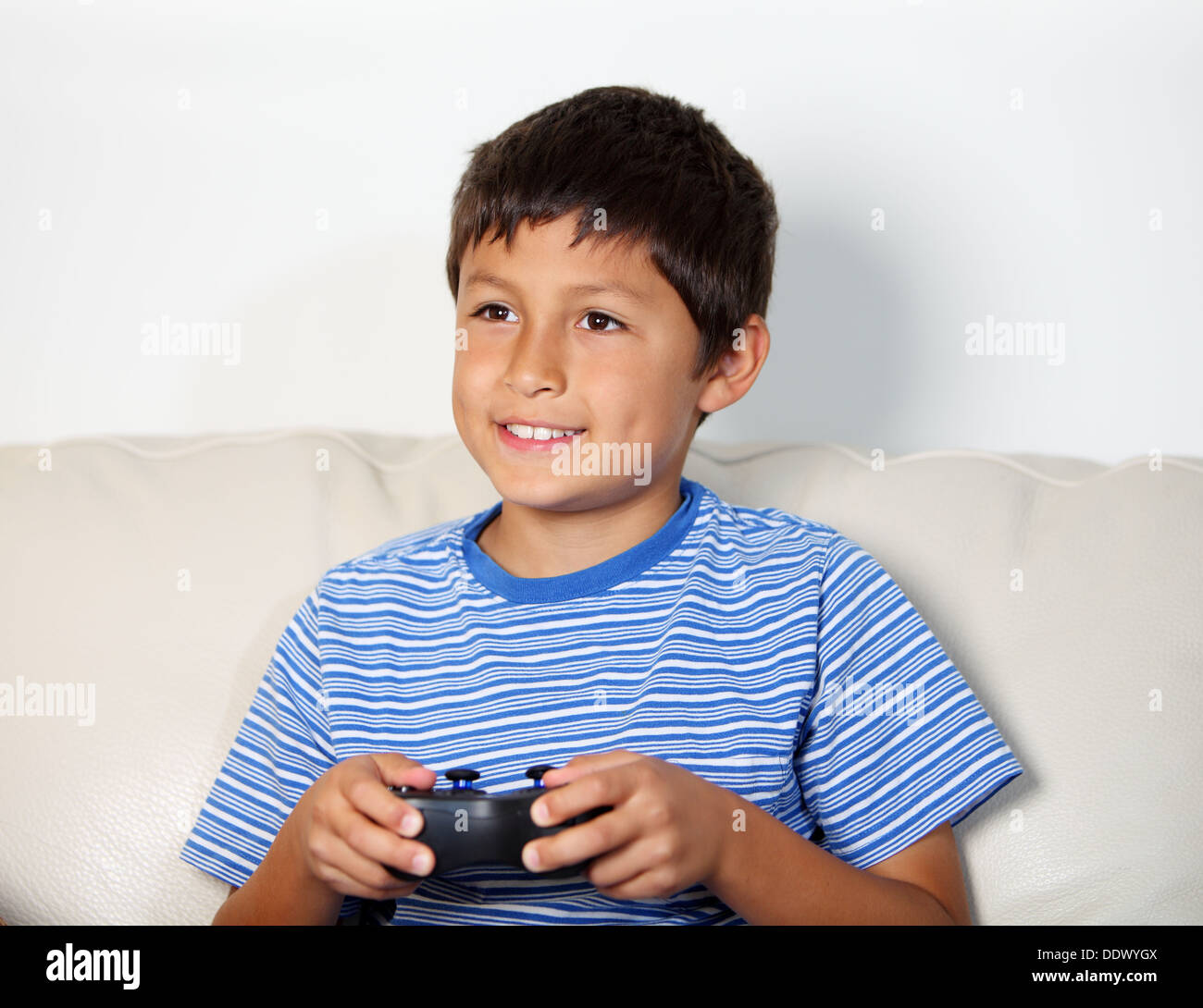 Young boy playing computer game while relxing on the sofa Stock Photo