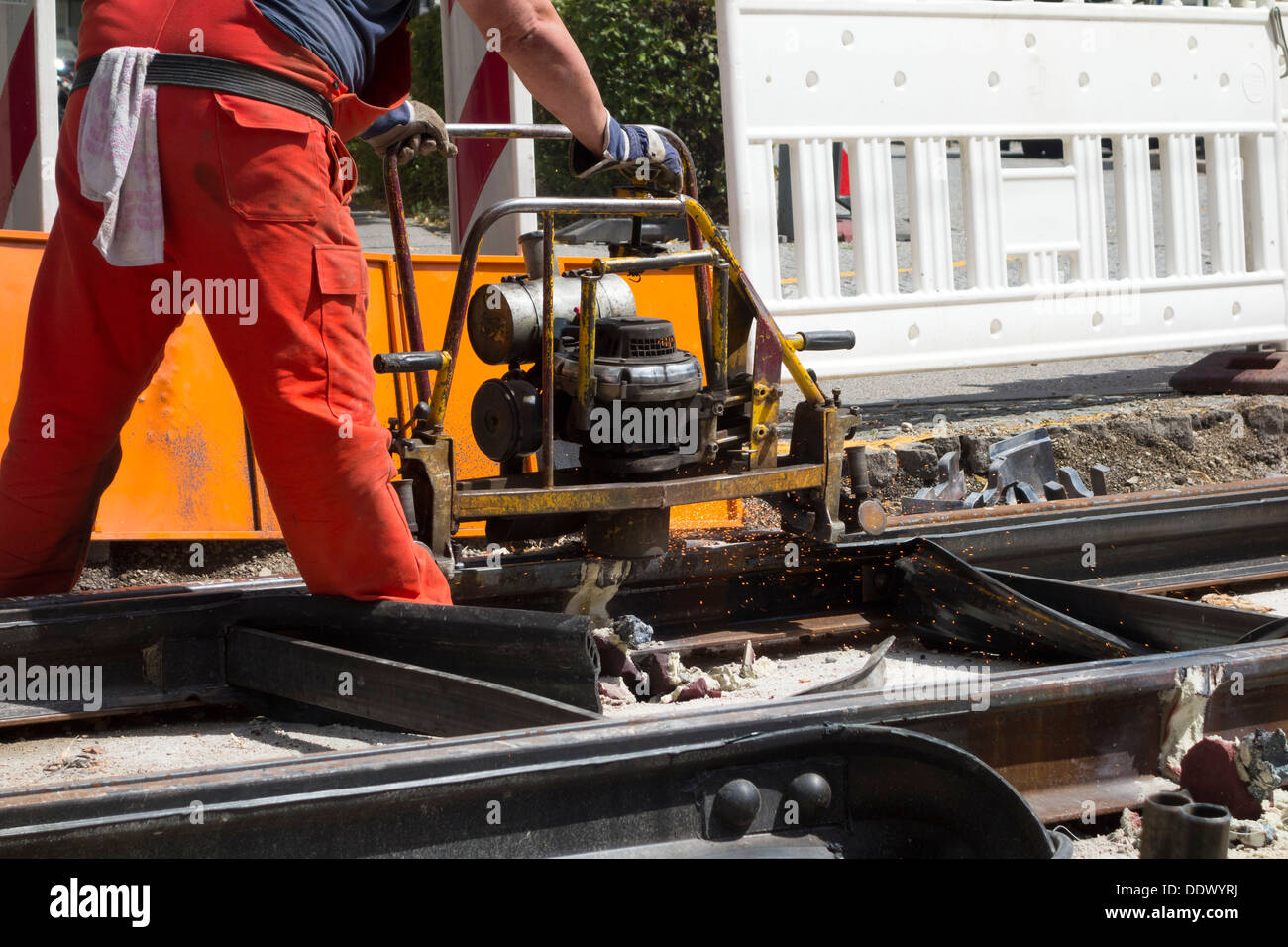 Man machine grinding a Tram Line after being welded, Munich Upper Bavaria Germany Stock Photo