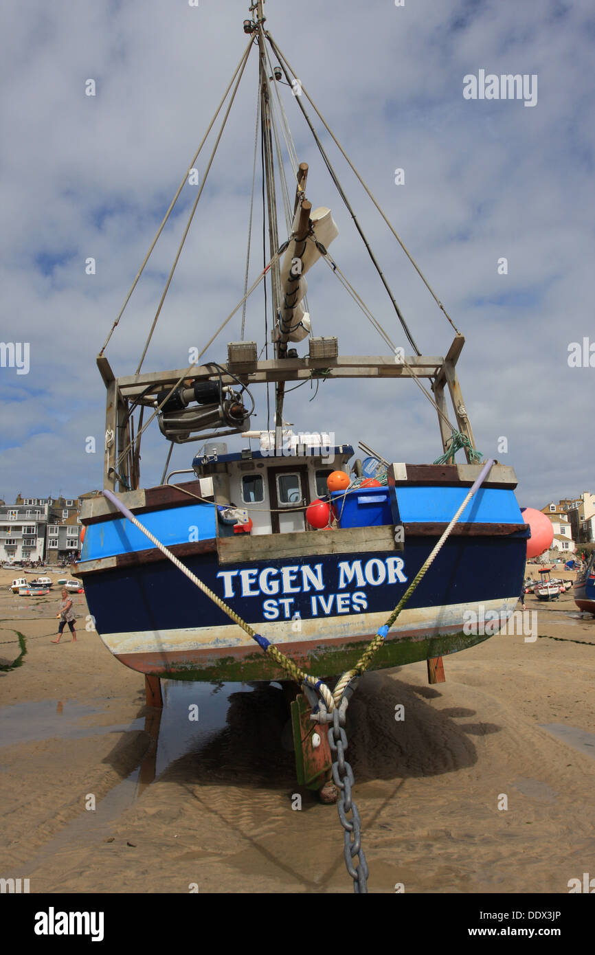 The fishing boat Tegen Mor settles on the sand waiting for the tide to come  back, in St.Ives harbor. Stock Photo