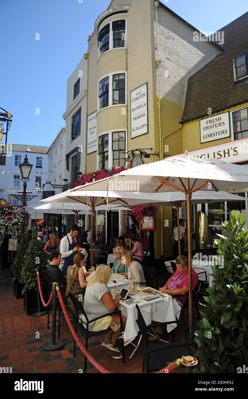 Waiter serving customers at English's seafood and oyster bar restaurant alfresco style outside in The Lanes area of Brighton UK Stock Photo