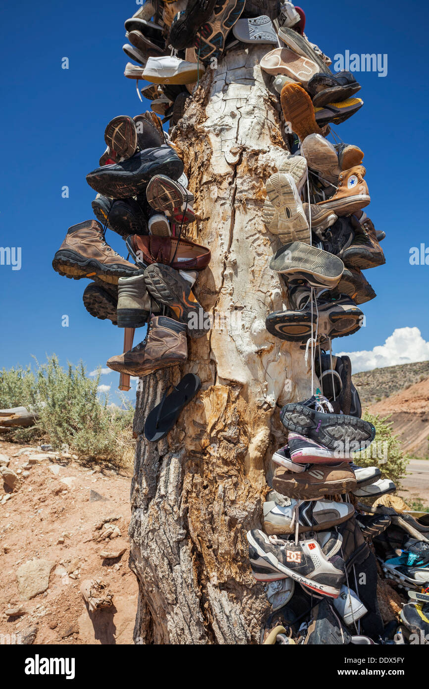 Tree trunk covered in shoes from travelers passing by, Virgin, Utah Stock Photo