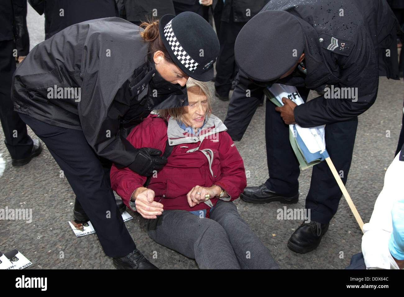 London, UK. 8th Sep, 2013.  Police officers remove a  protestor who had been blocking the road outside one of the entrances to the Excel Center, which is holding London's arms fair. Credit:  nelson pereira/Alamy Live News Stock Photo