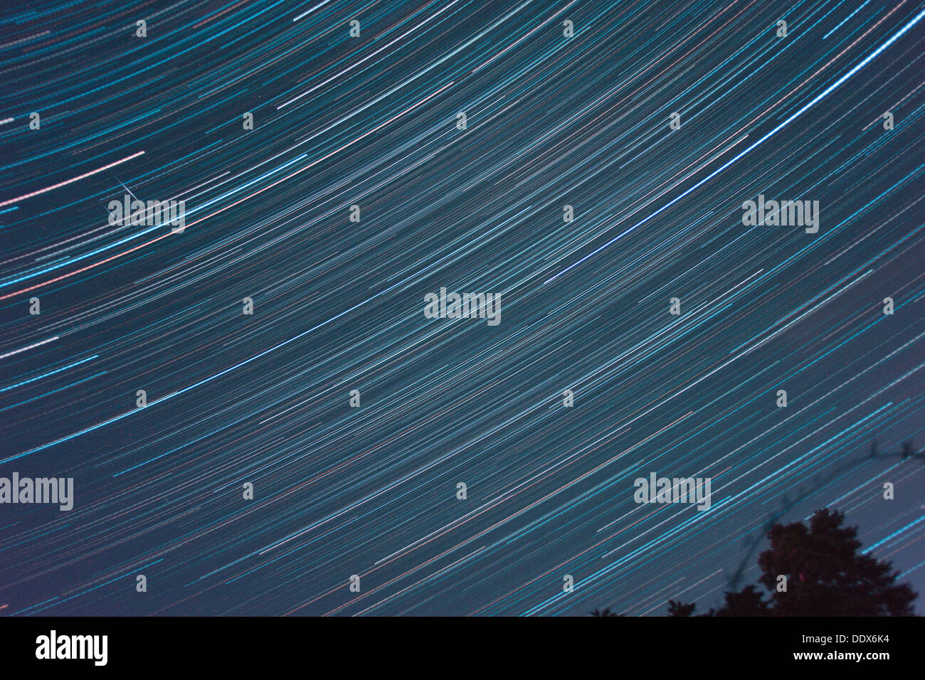 Star trails and two parallel satellite trails in a 4hr exposure image of dark skies in southern France. Stock Photo