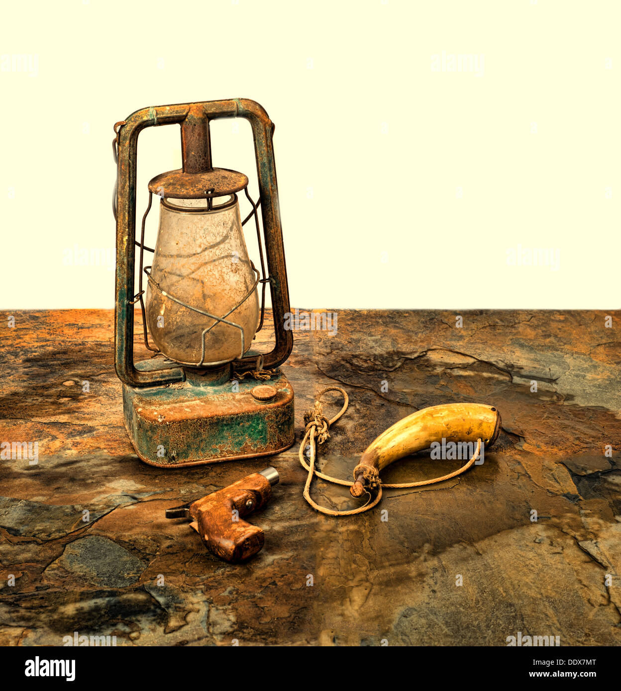 Antique pistol and powder horn with an old lantern on slate with a beige background Stock Photo