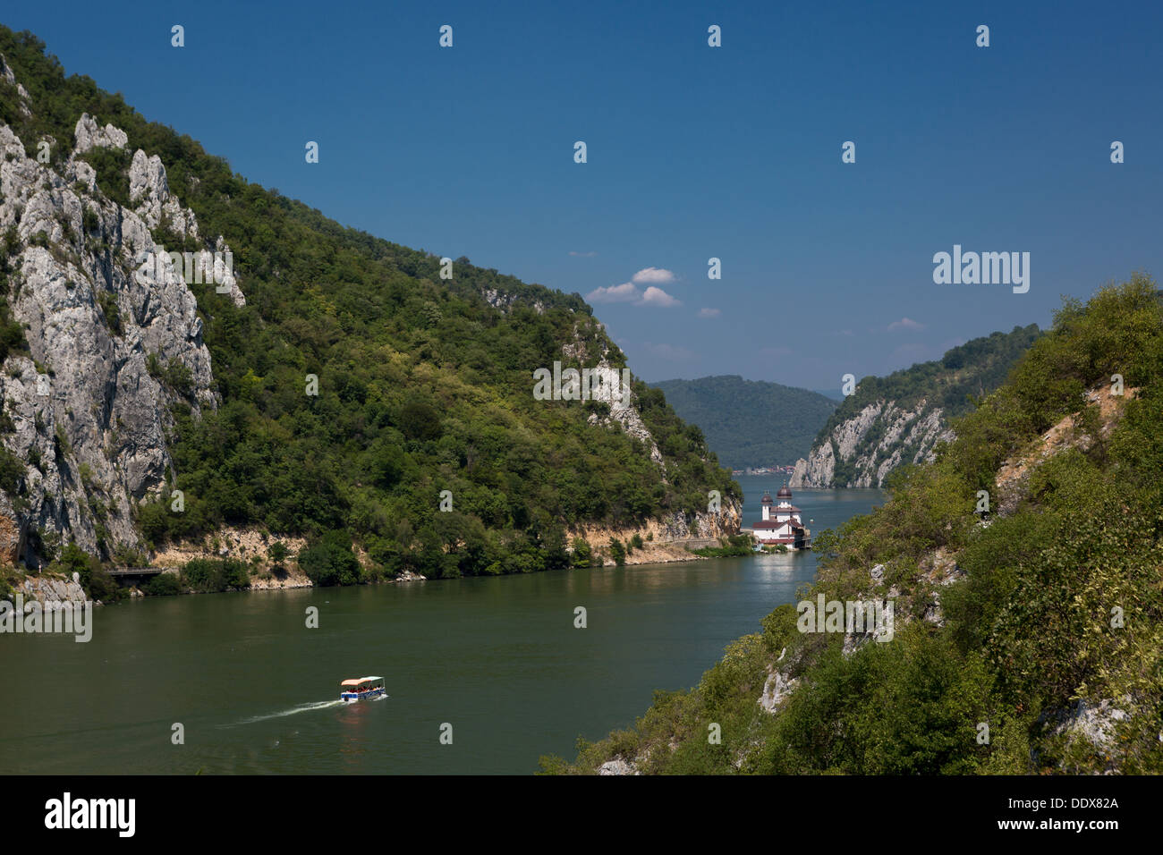 Danube Gorges landscape with a boat sailing towards the Mraconia monastery Stock Photo
