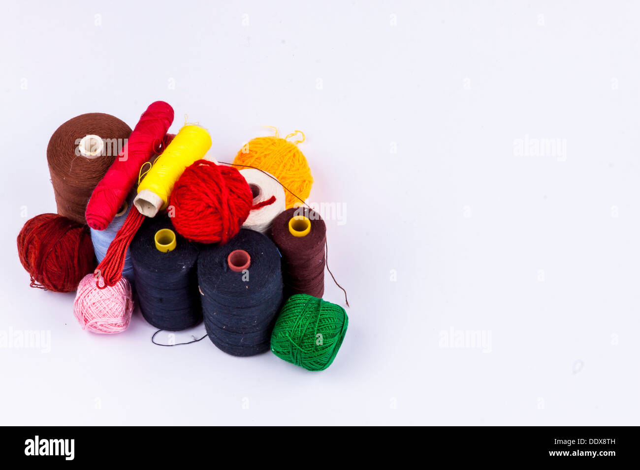 Colourful threads and wool on white background. Stock Photo