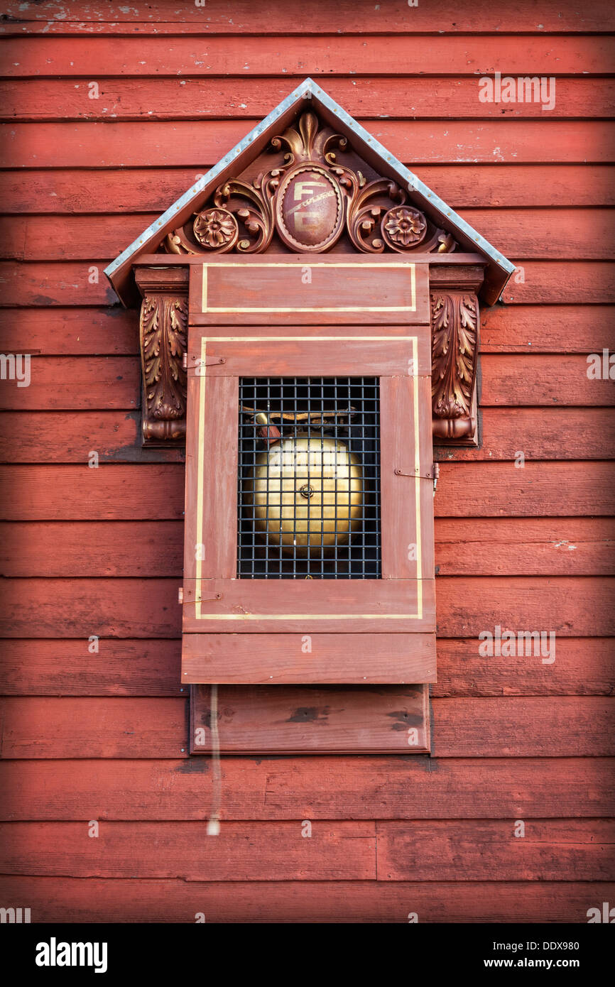 Antique fire alarm on side of red fire house, South Dakota Stock Photo