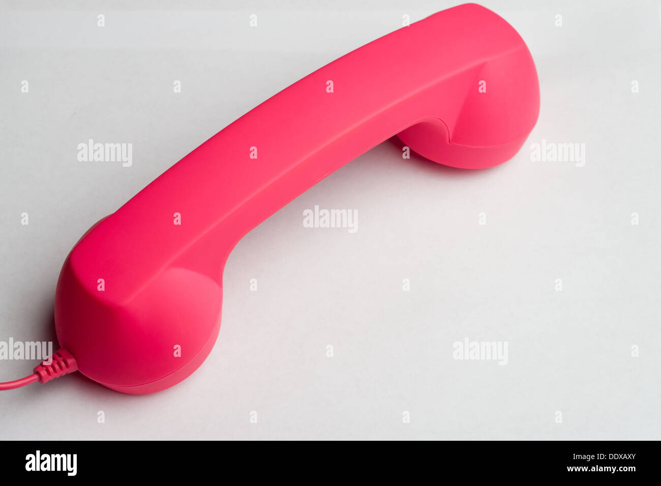 Hot pink phone face down on white surface Stock Photo