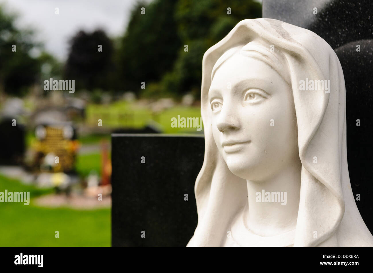 Statue of the Virgin Mary in a graveyard Stock Photo