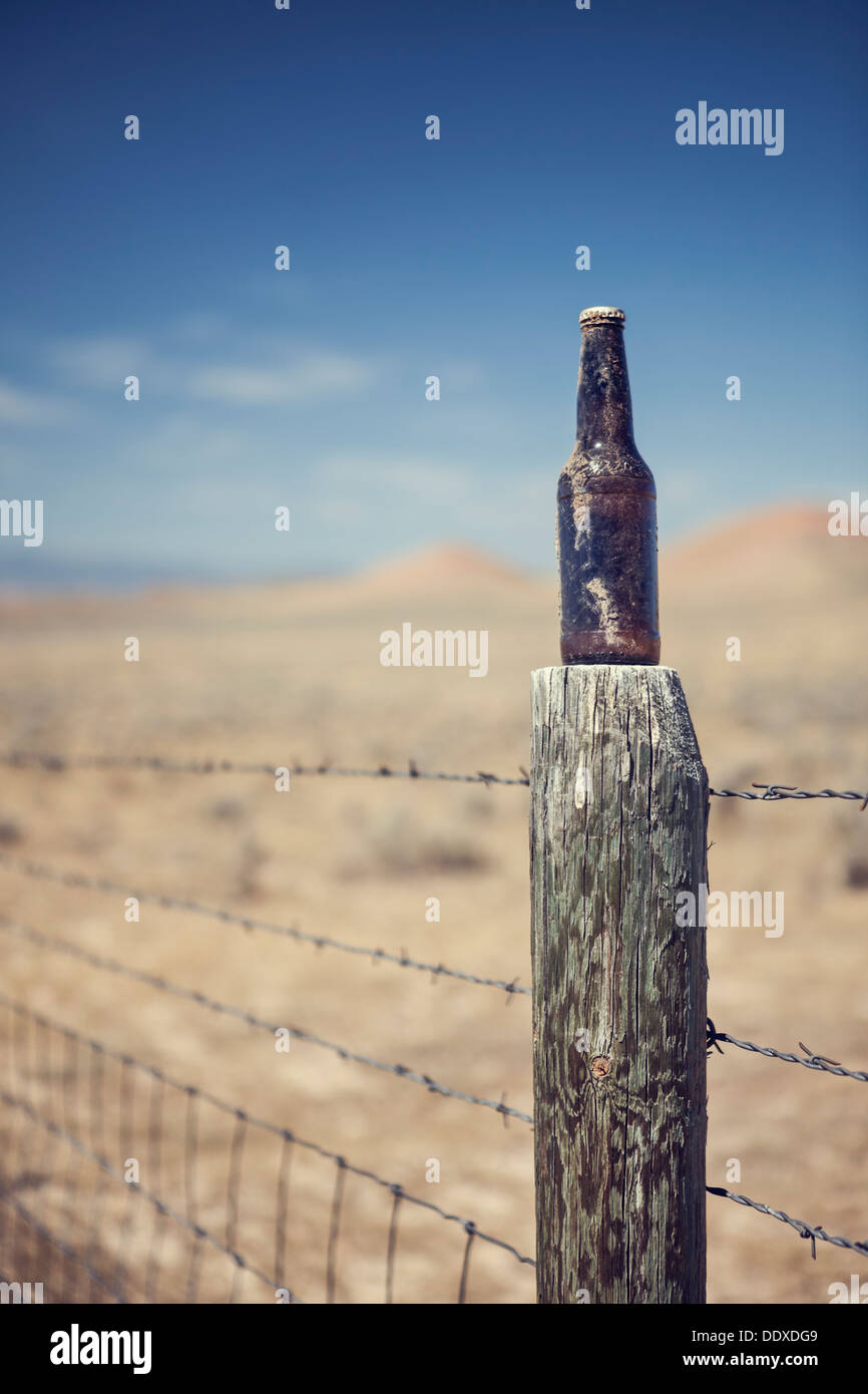 Beer bottle on fence post near Buffalo, Wyoming Stock Photo