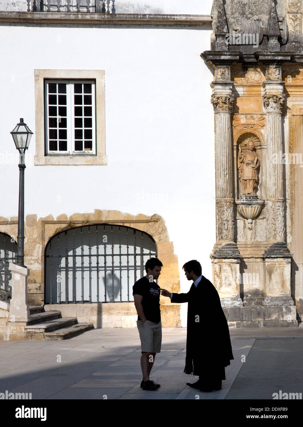 Student being spoken to in Courtyard of the old University of Coimbra, Coimbra, Portugal Stock Photo