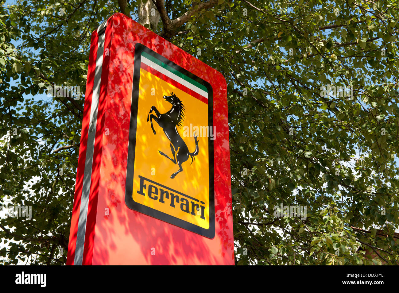 A Ferrari sign stands outside a dealdership in Lyndhurst in the New Forest National Park in Hampshire (Editorial use only). Stock Photo