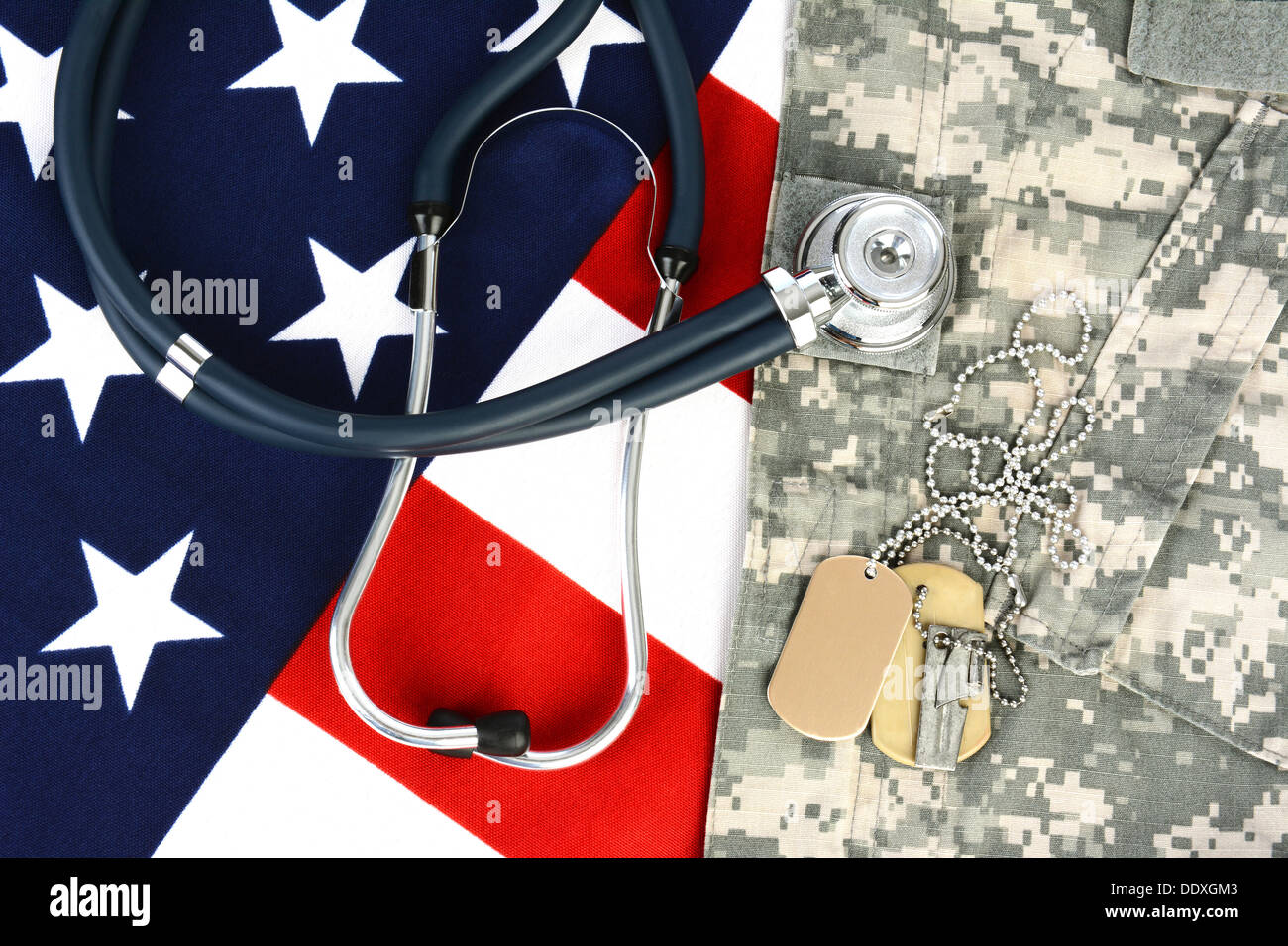 Military fatigues and dog tags on an American Flag with a stethoscope to illustrate health care in the armed services. Stock Photo