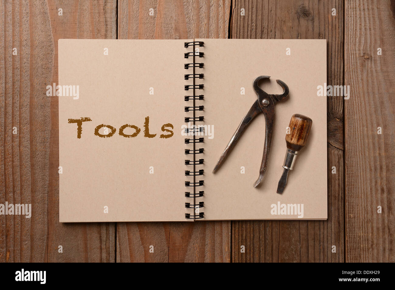 Two tools on the blank page of a notebook. The opposite page has the word Tools spelled out. Stock Photo