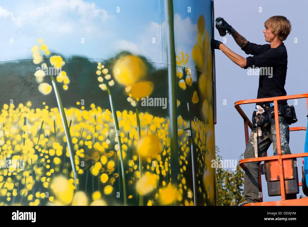 The graffiti artist Daniel Wrede sprays rape flowers onto a former gas