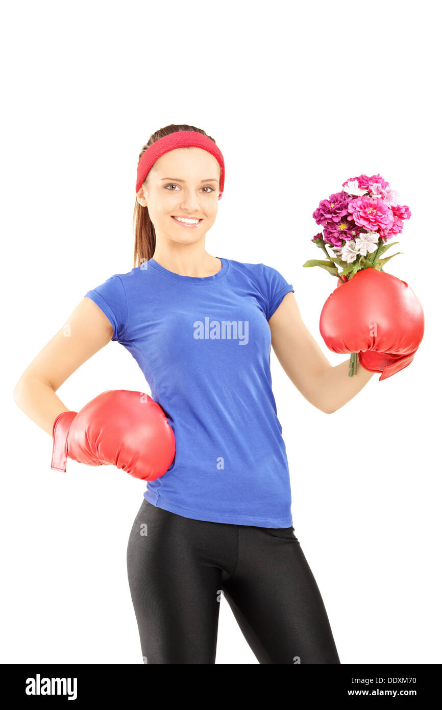 Female athlete wearing boxing gloves and holding a bunch of flowers Stock Photo