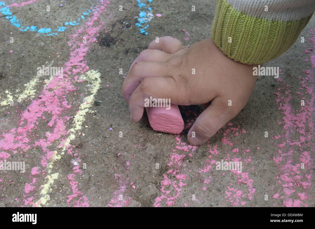 hand of child holds the piece of chalk Stock Photo