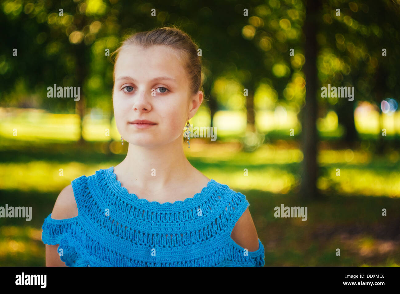 Closeup portrait of beautiful young girl in blue knitted dress in the ...