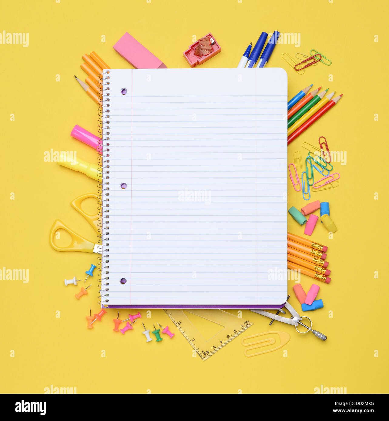 An open spiral notebook laying on assorted school supplies. Back to School concept. Stock Photo