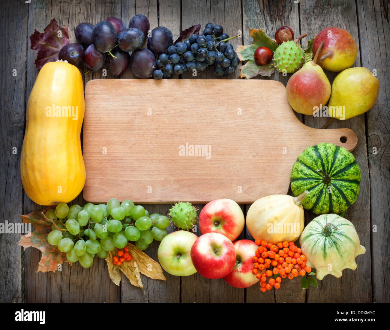 Autumn fruits and vegetables and empty cutting board background Stock Photo