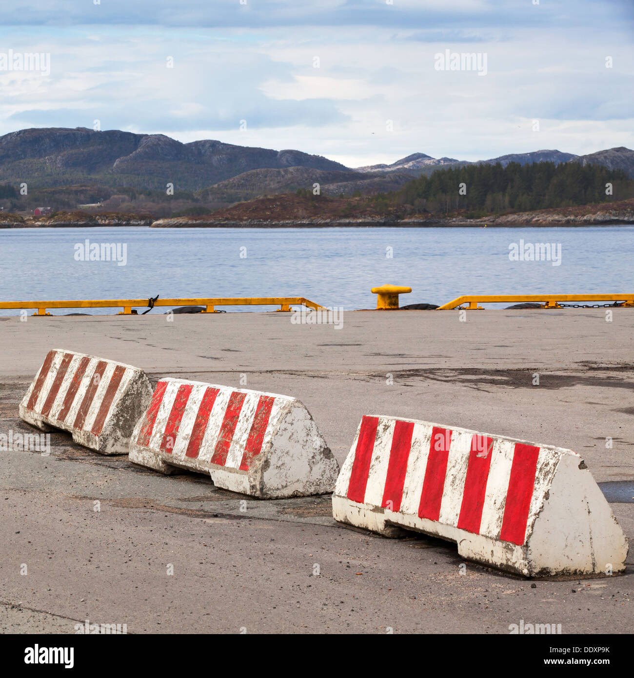 Striped red and white concrete road barriers lie on the seacoast Stock ...