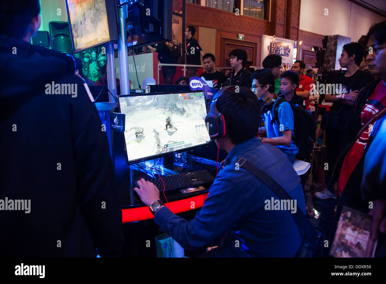 Jakarta, Indonesia, 8th September 2013: Several visitors playing video games on one of the stands at Indo Game Show 2013. Stock Photo