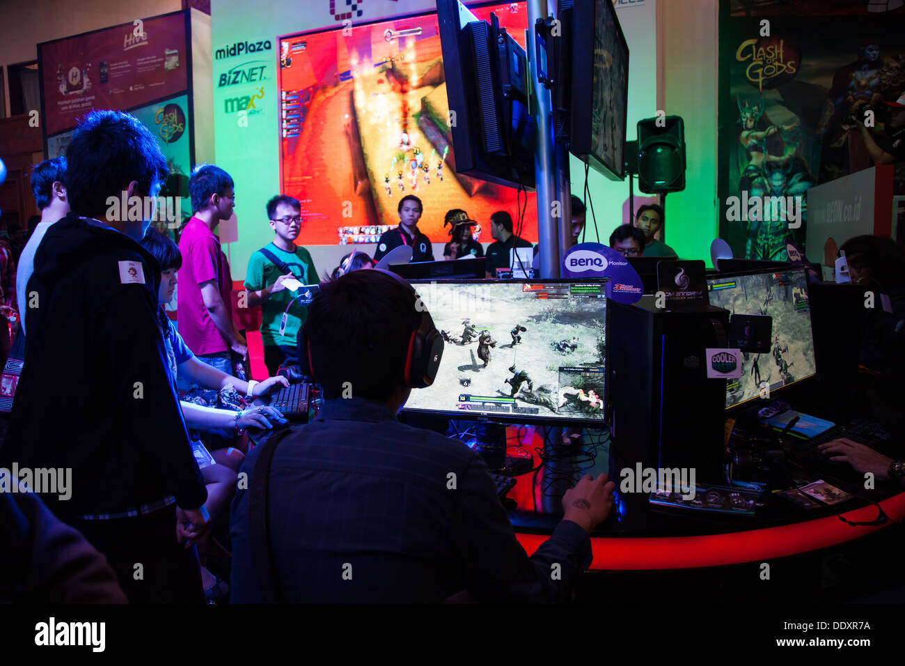 Jakarta, Indonesia, 8th September 2013: Several visitors playing video games on one of the stands at Indo Game Show 2013. Stock Photo