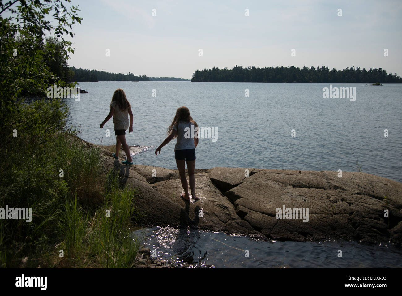 Girls Walking On The Rocks At The Lakeside Lake Of The Woods Kenora Ontario Canada Stock