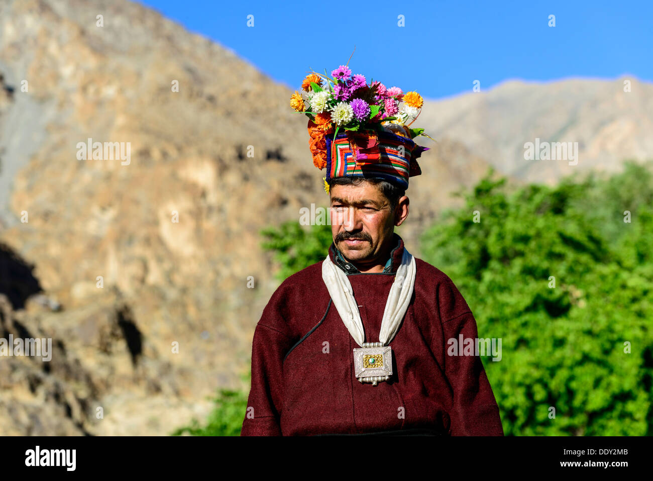 Man of the Brokpa tribe wearing traditional dress with flower headdress Stock Photo