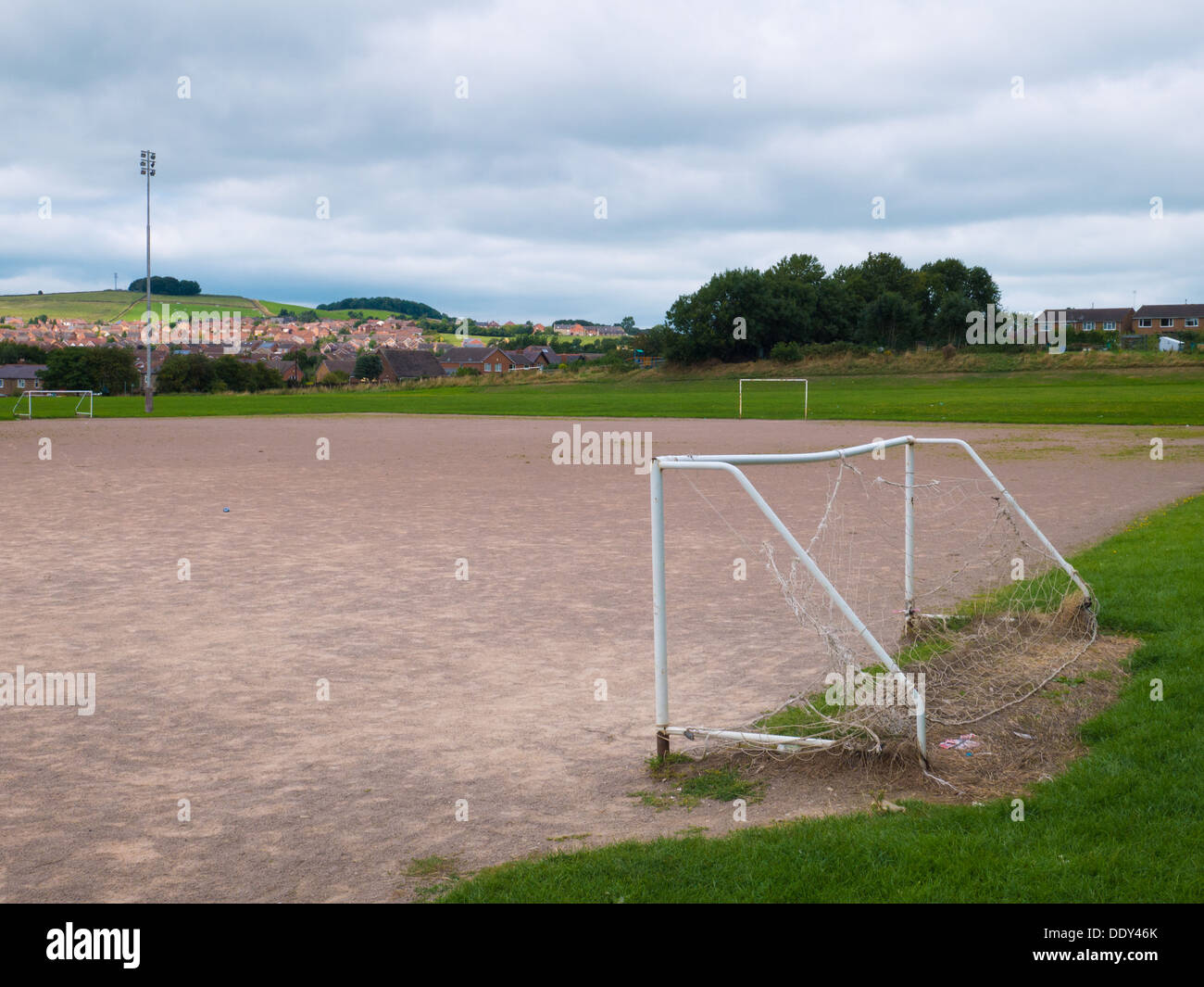 Public football fields with goal posts and flood lights set against