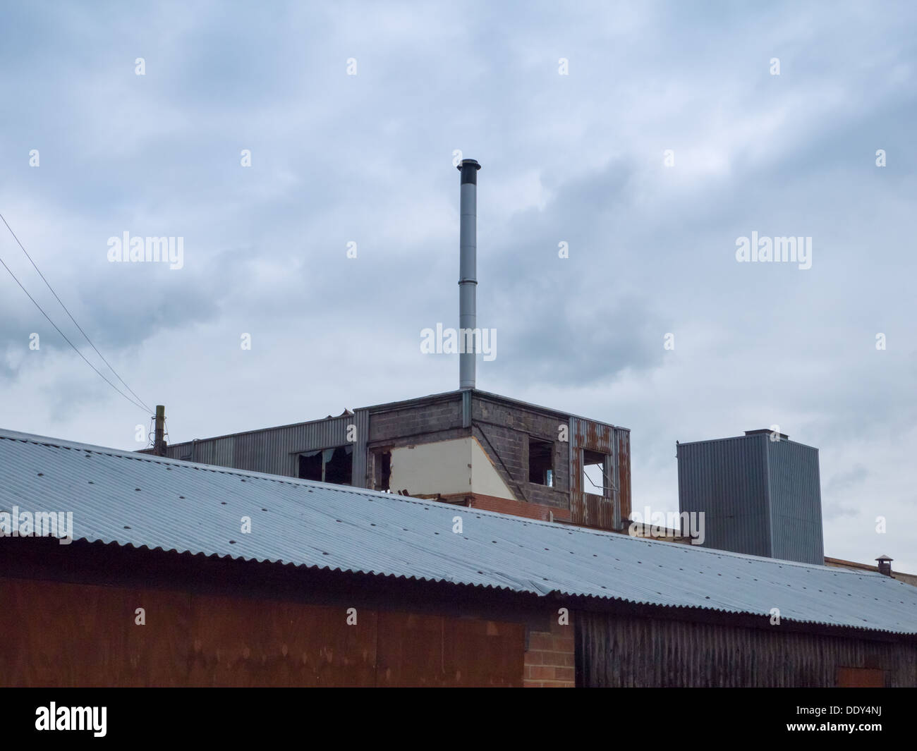 Abandoned and derelict factory in Belper Derbyshire, with an old chimney. Stock Photo