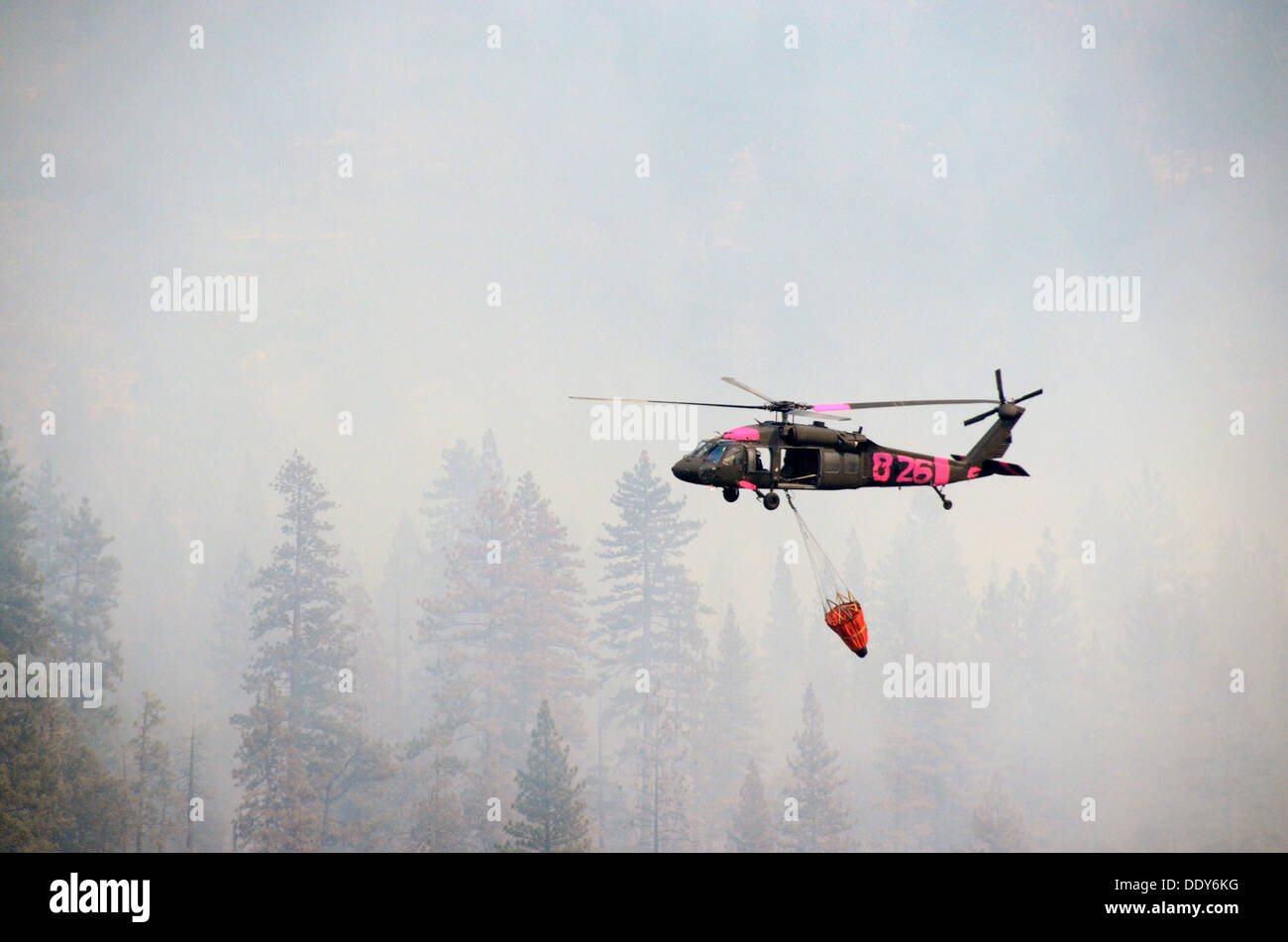 A California Air National Guards Black Hawk helicopter drops water on the Rim Fire during firefighting operations August 29, 2013 near Yosemite, CA. Stock Photo