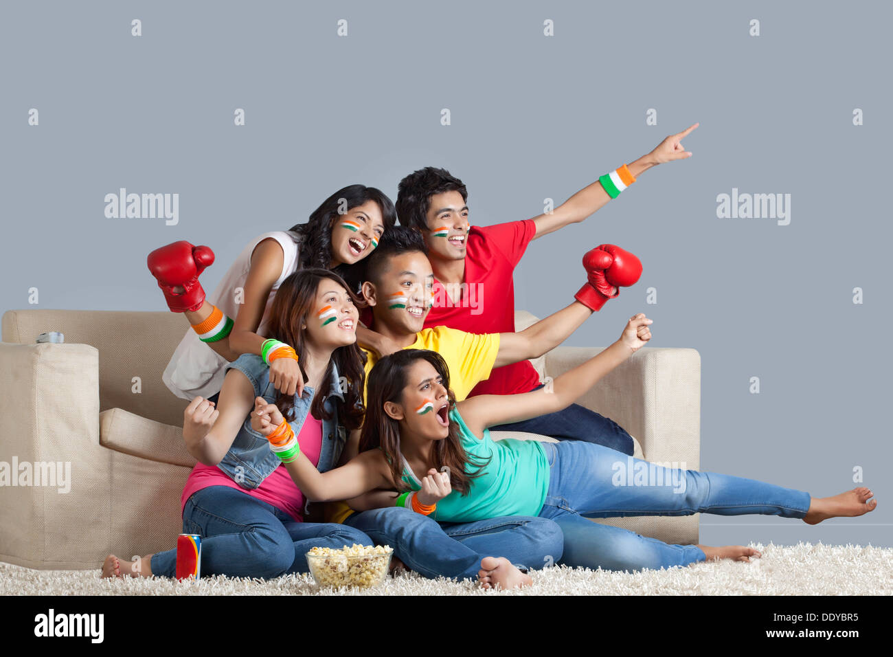 Excited young friends watching boxing match together at home Stock ...
