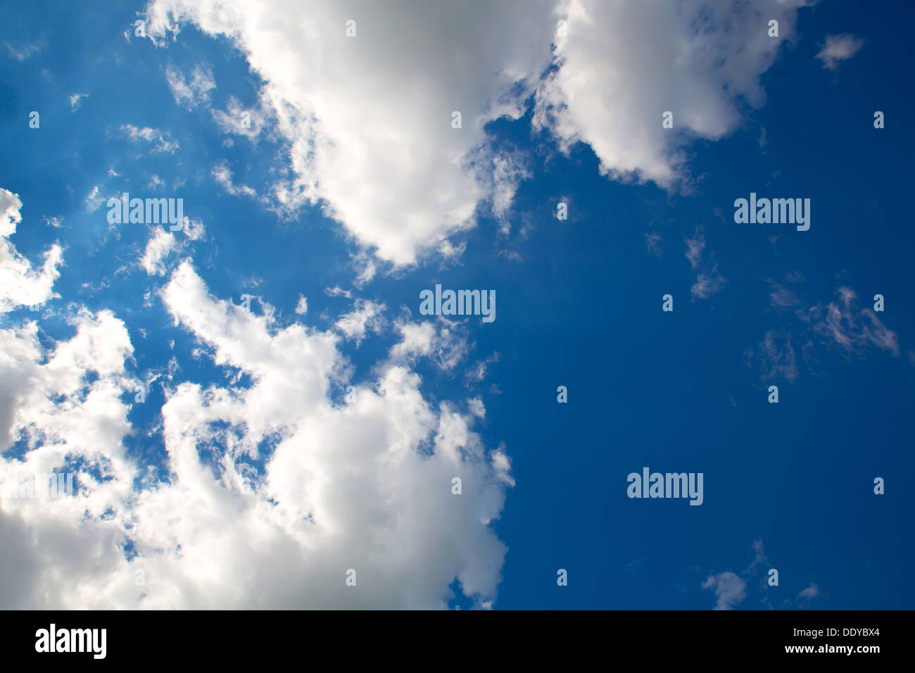 A blue sky with some fluffy clouds Stock Photo - Alamy