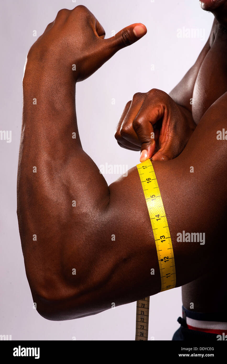 Image of muscular man measure his biceps with measuring tape in centimeters  Stock Photo - Alamy