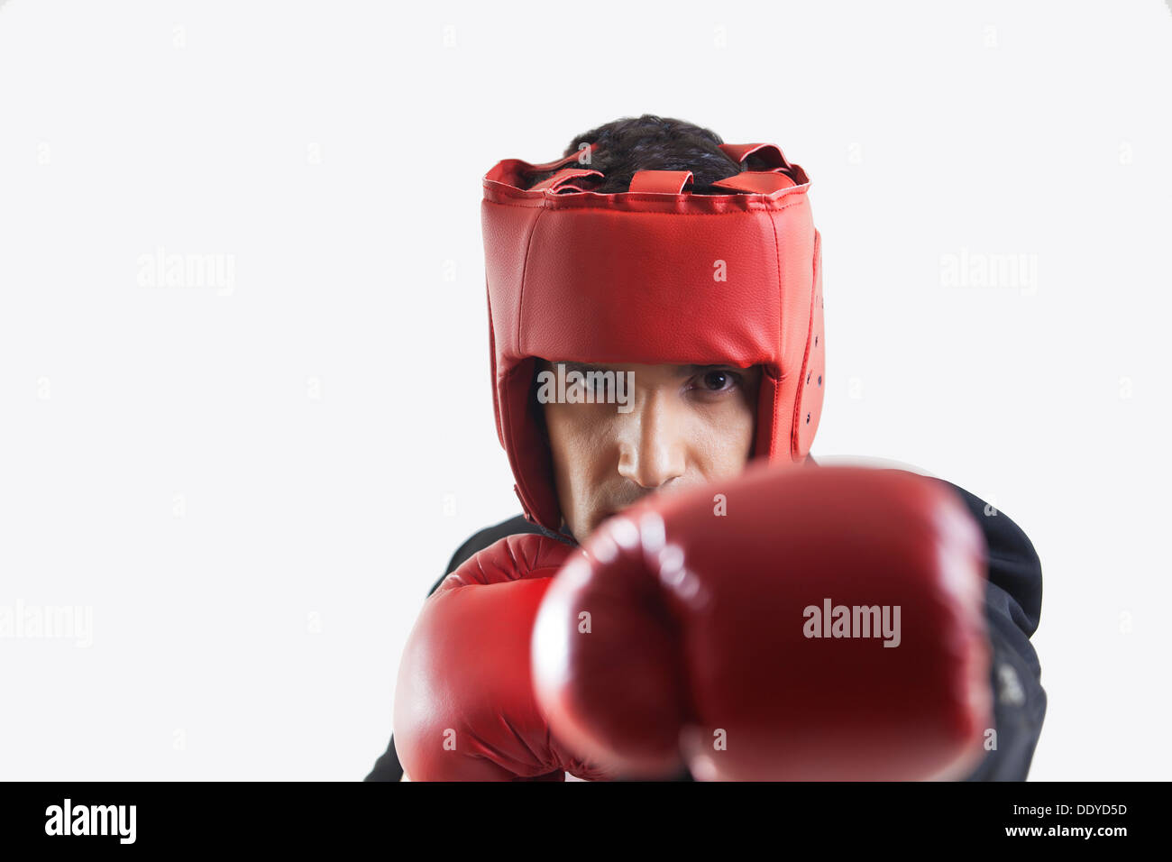 Businessman with boxing gloves punching Stock Photo Alamy