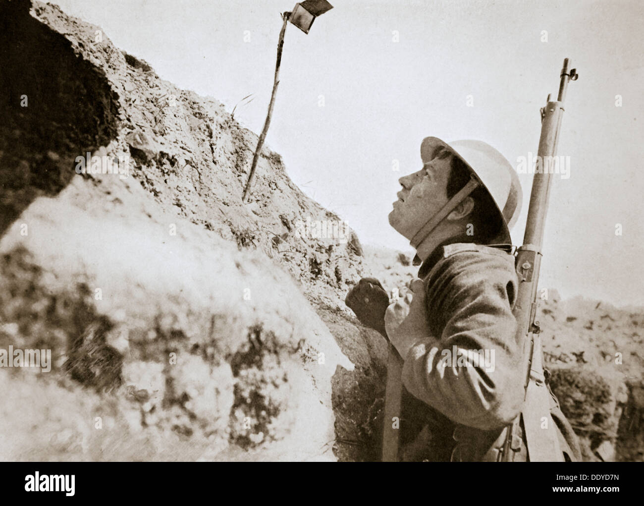 A sentry in the trenches looking through an improvised persicope, France, World War I, 1916. Artist: Unknown Stock Photo