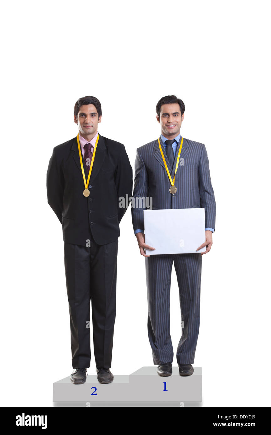 Businessmen with medals standing on a podium Stock Photo