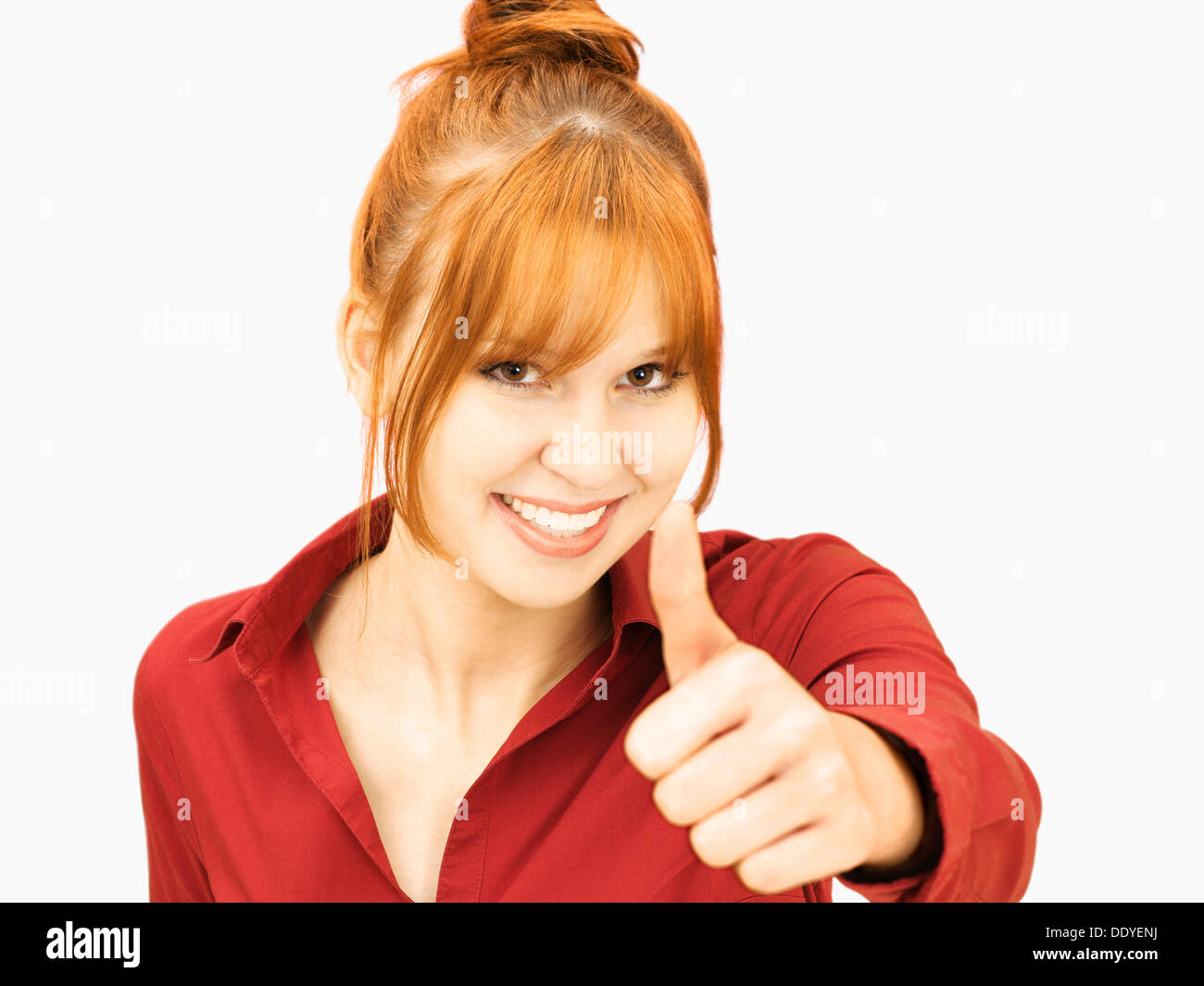 Cheerful young woman making thumbs up gesture Stock Photo - Alamy