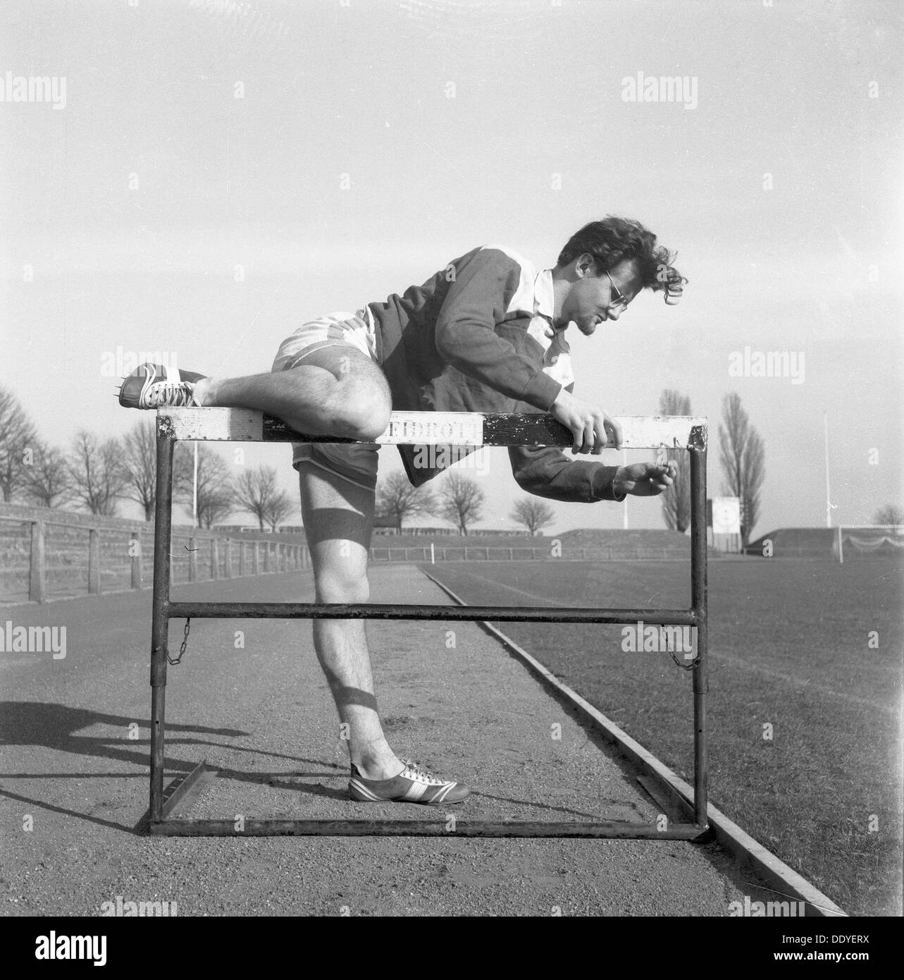 Adjusting a hurdle on an athletics track, Landskrona, Sweden, 1955. Artist: Unknown Stock Photo